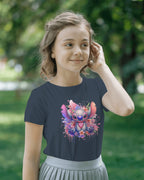Young girl wearing a navy blue t-shirt with a colorful cartoon character design outdoors.