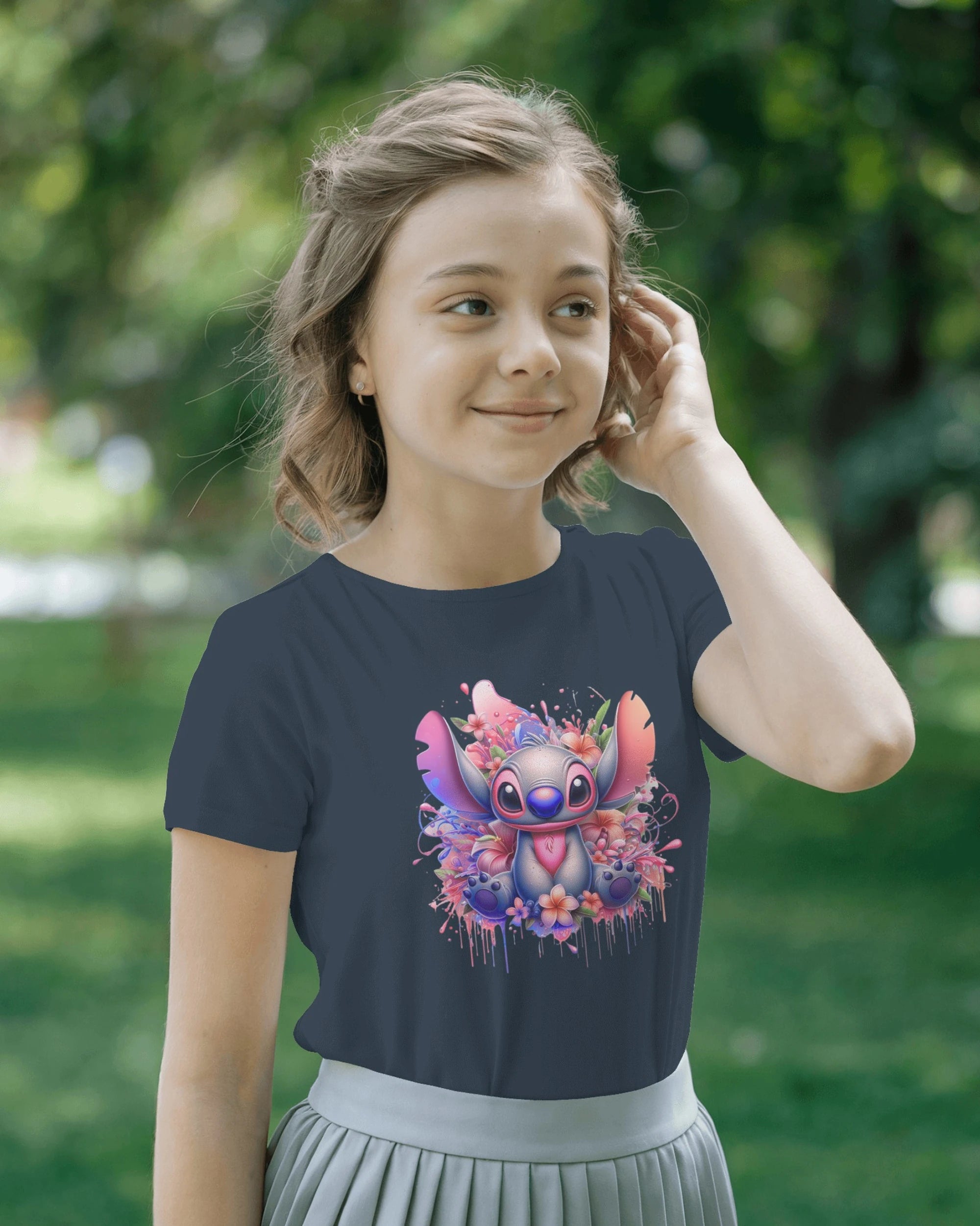 Young girl wearing a navy blue t-shirt with a colorful cartoon character design outdoors.
