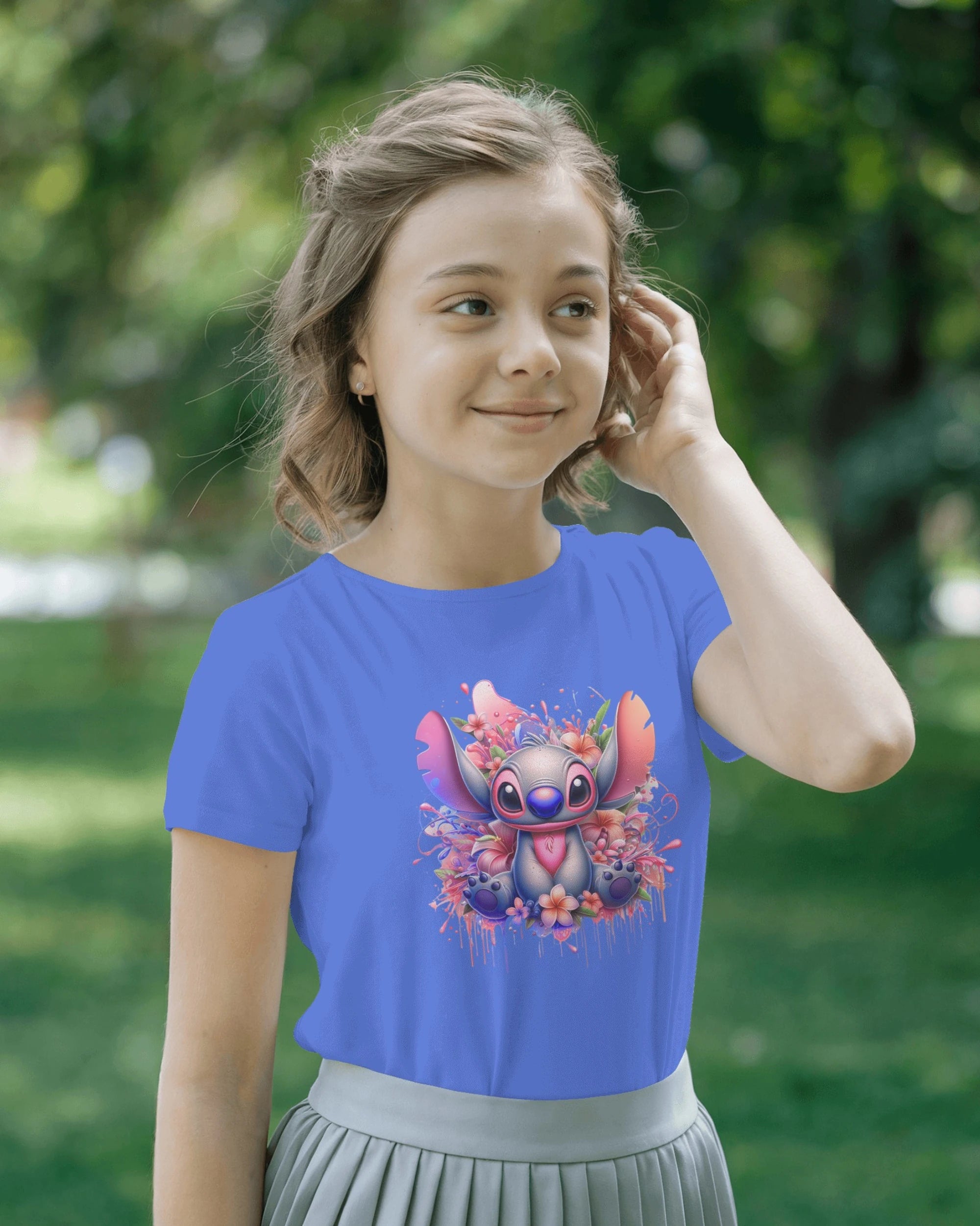 Girl wearing a blue t-shirt with a cartoon character design outdoors.