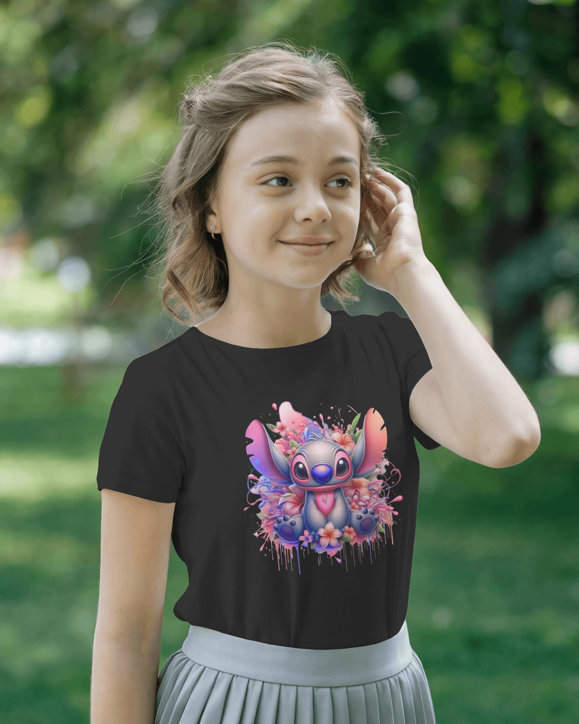 Young girl wearing a black t-shirt with a colorful character design outdoors.