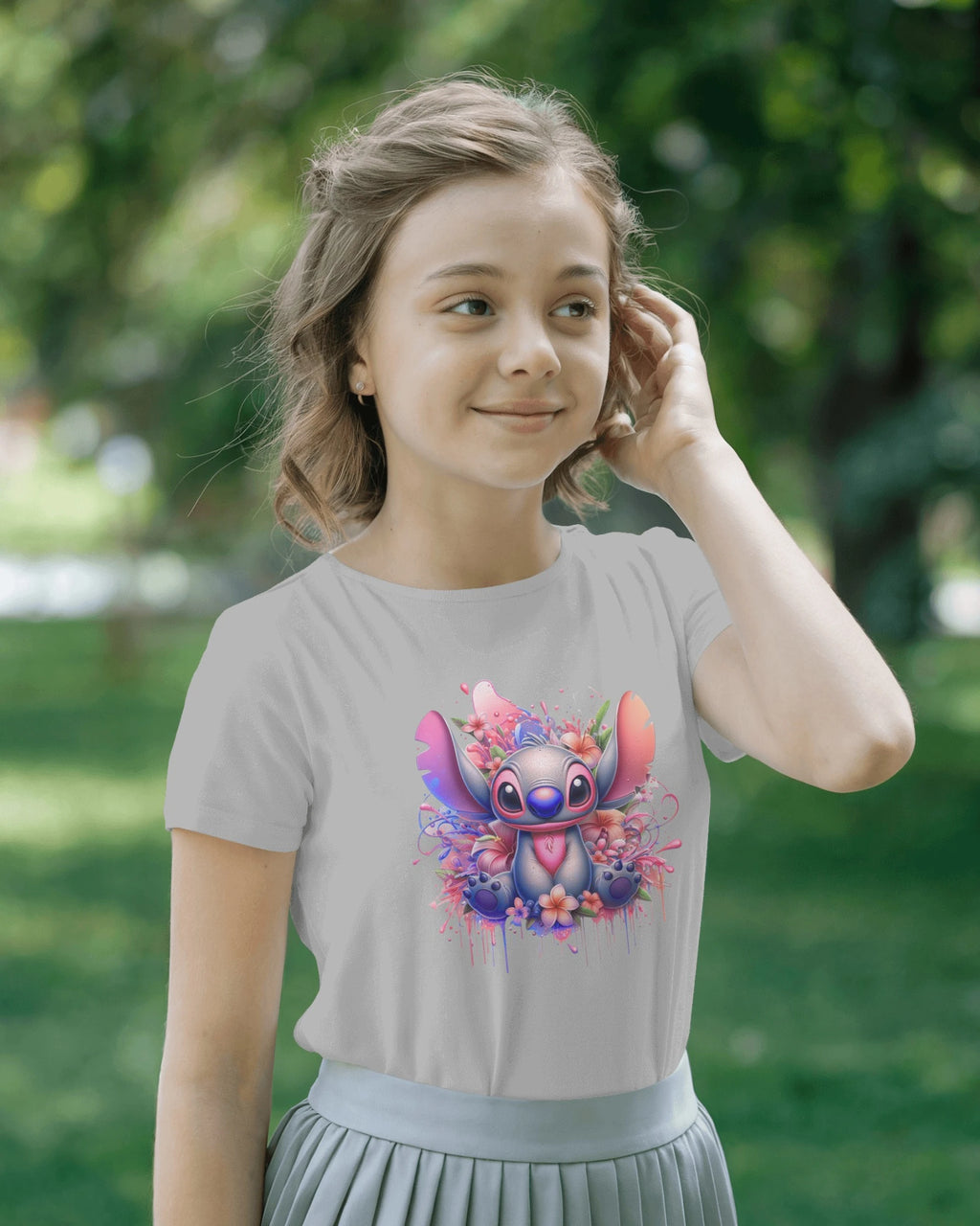 Young girl wearing a t-shirt with a colorful character design outdoors.