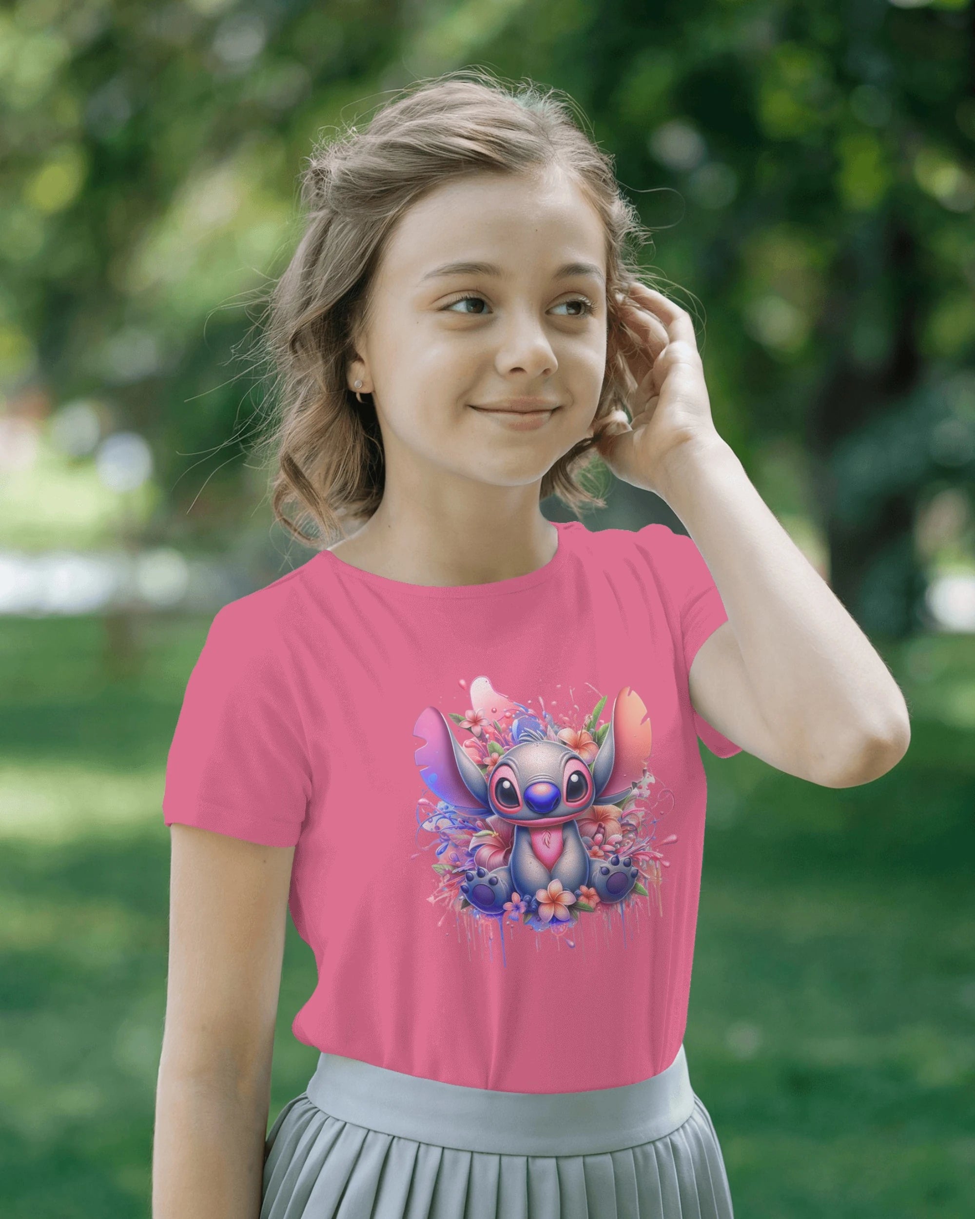 Young girl wearing a pink t-shirt with a cartoon character design outdoors.