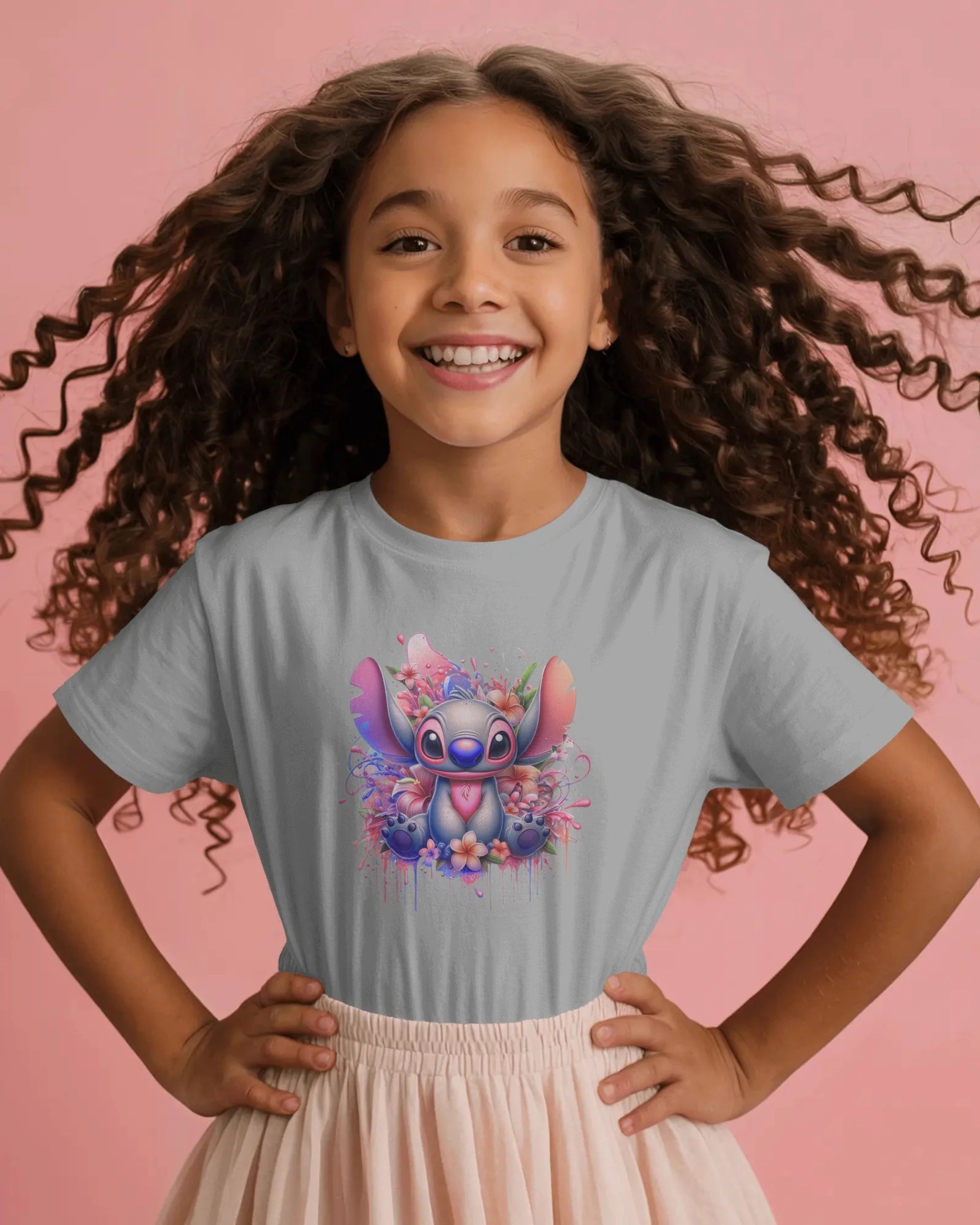 Child wearing a gray t-shirt with a cartoon character design on a pink background