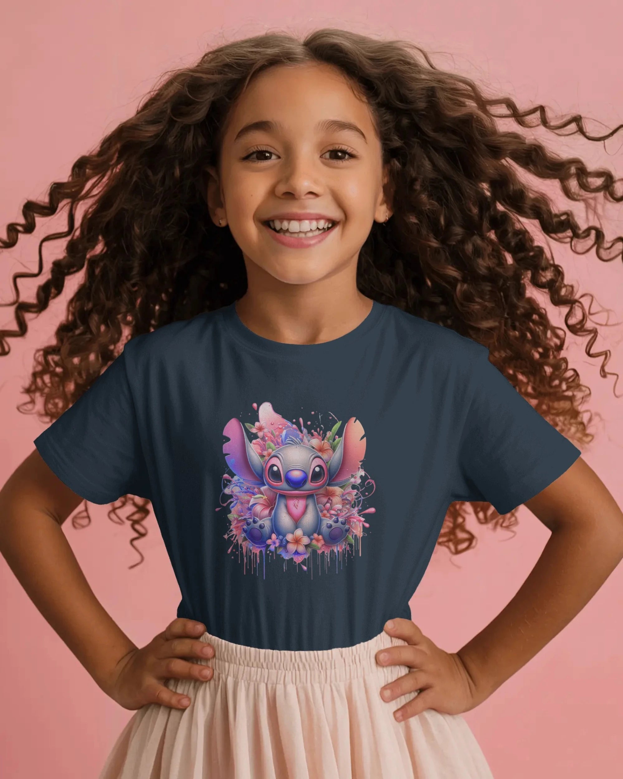 Child wearing a navy blue t-shirt with a colorful cartoon character design on a pink background