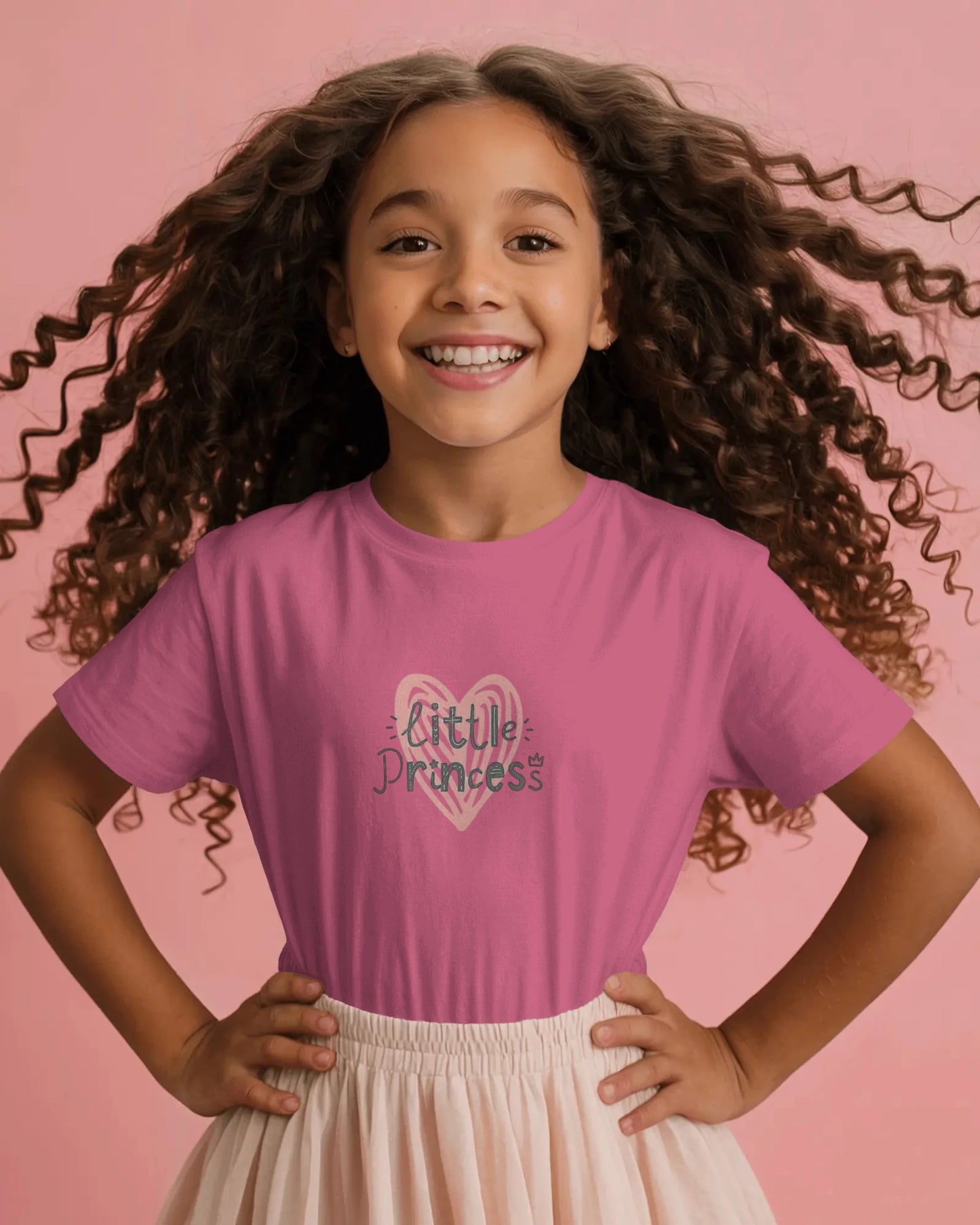 Young girl wearing a pink t-shirt with a unicorn design on a pink background