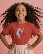 Young girl wearing a red t-shirt with a graphic design on a pink background