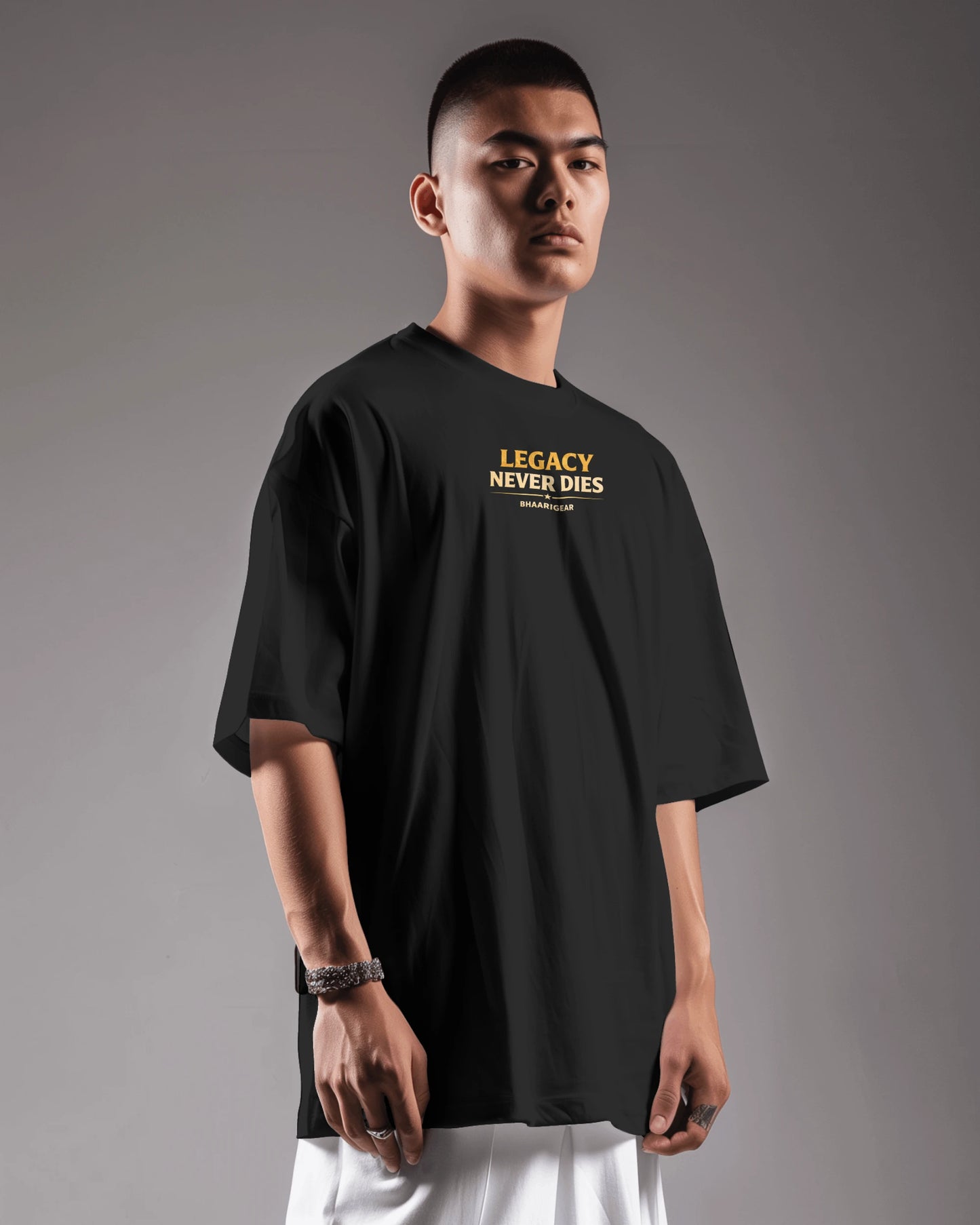 Person wearing a black t-shirt with 'Legacy Never Dies' text on a gray background