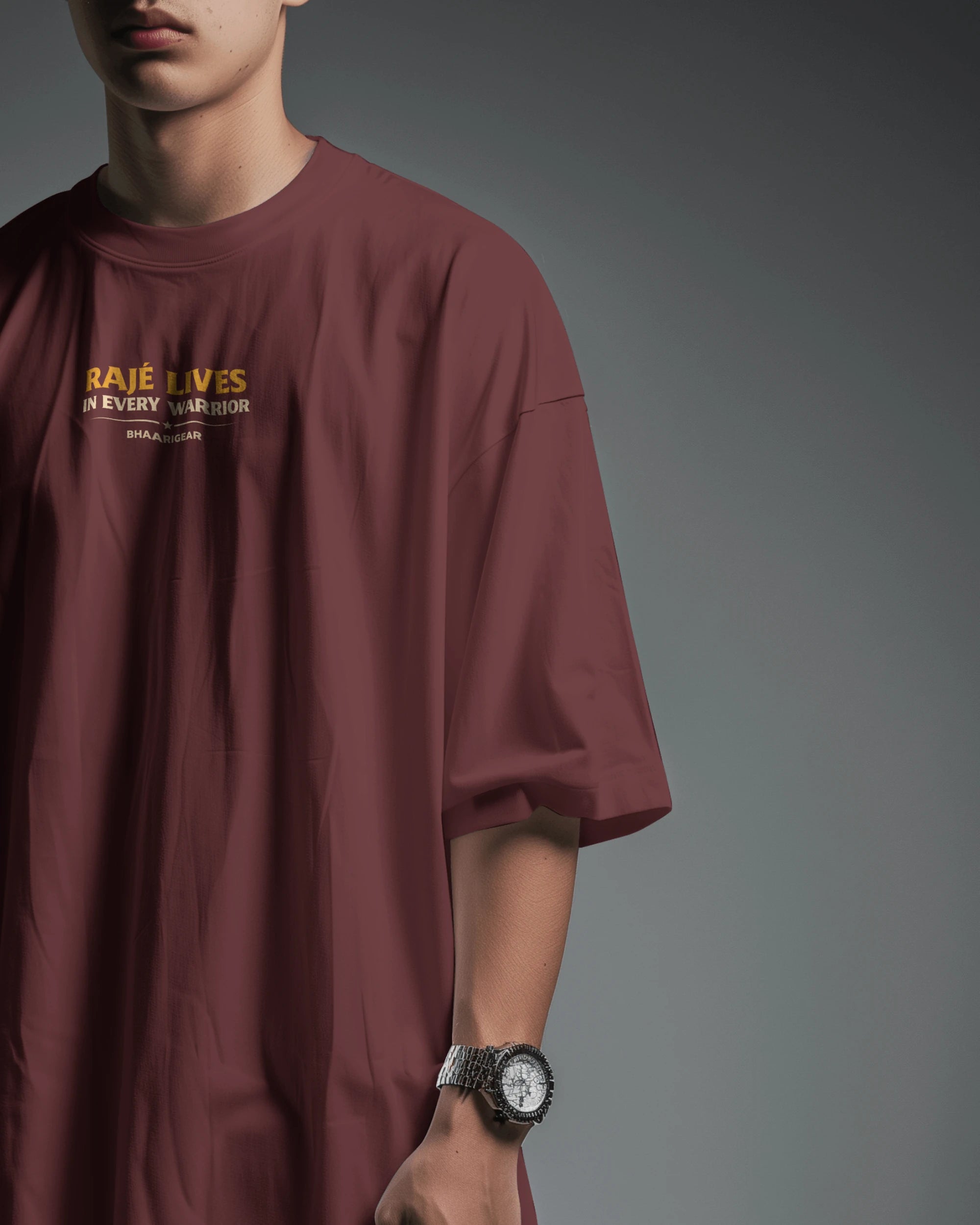 Maroon Raje Lives Warrior oversized graphic T-shirt by BhaariGear, front half-side view showing bold design and relaxed fit.
