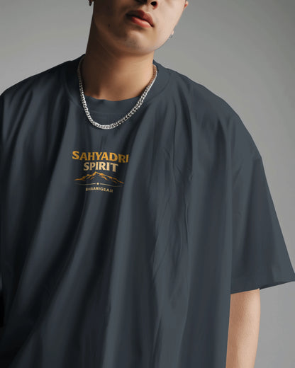 Asian model wearing BhaariGear Sahyadri Spirit Warrior oversized T-shirt in a casual scene, showcasing the relaxed fit and bold design.