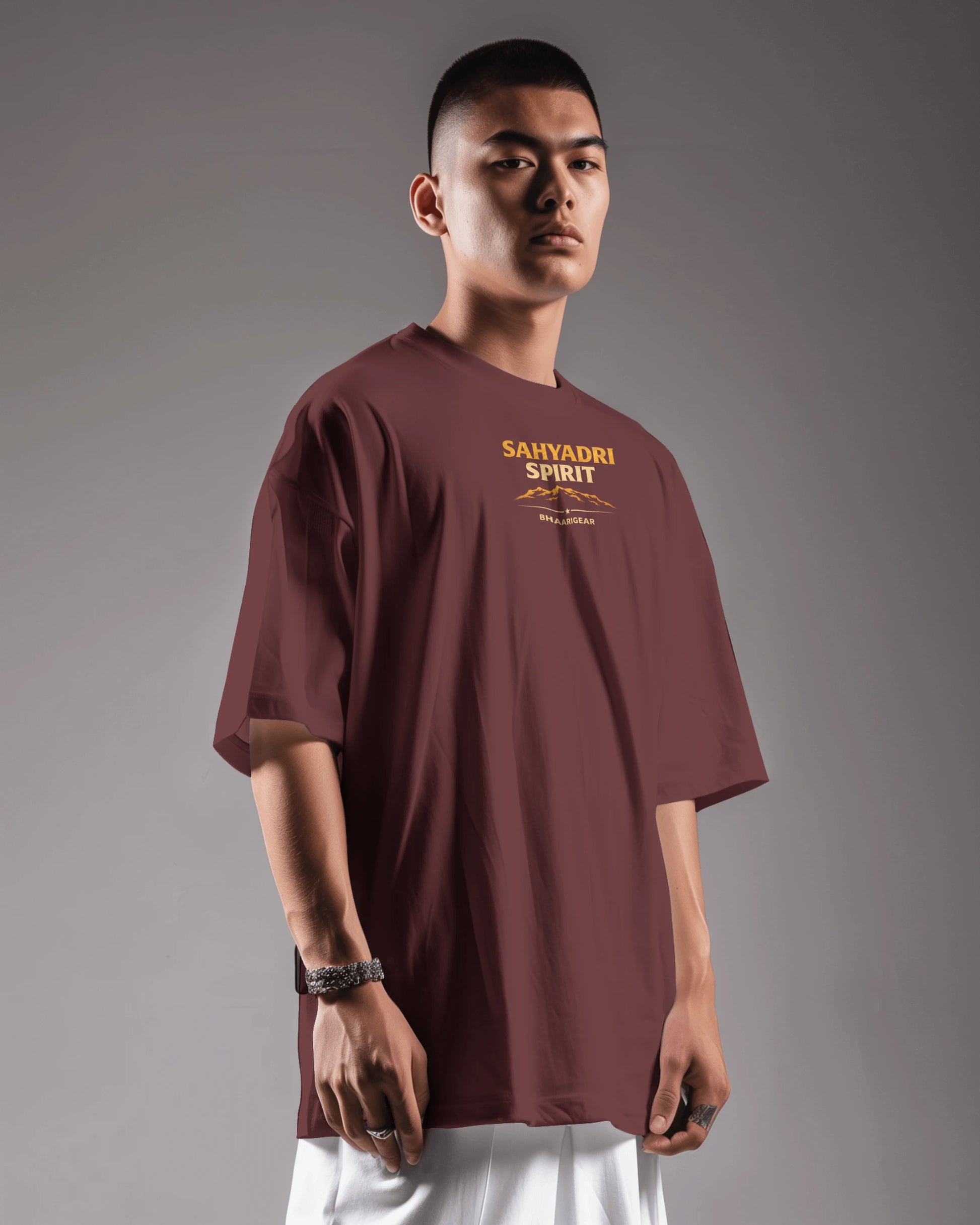 Asian model wearing Sahyadri Spirit Warrior oversized T-shirt by BhaariGear, showcasing relaxed fit and bold graphic design.