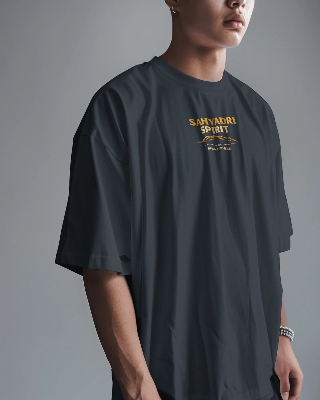 Asian model wearing BhaariGear Sahyadri Spirit Warrior oversized T-shirt, casual fit, front view, in a modern indoor setting.