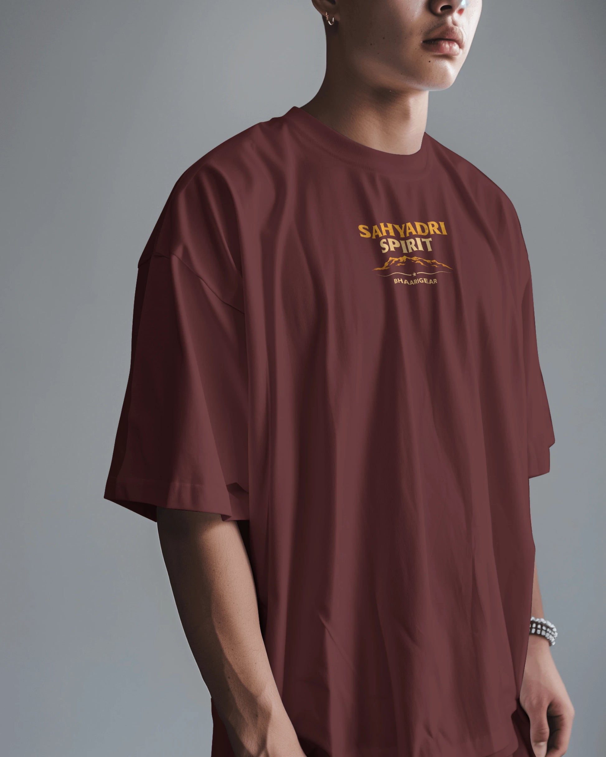 Asian male model wearing the oversized Sahyadri Spirit Warrior T-shirt by BhaariGear in a casual scene.