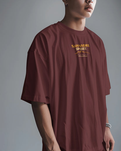 Asian male model wearing the oversized Sahyadri Spirit Warrior T-shirt by BhaariGear in a casual scene.
