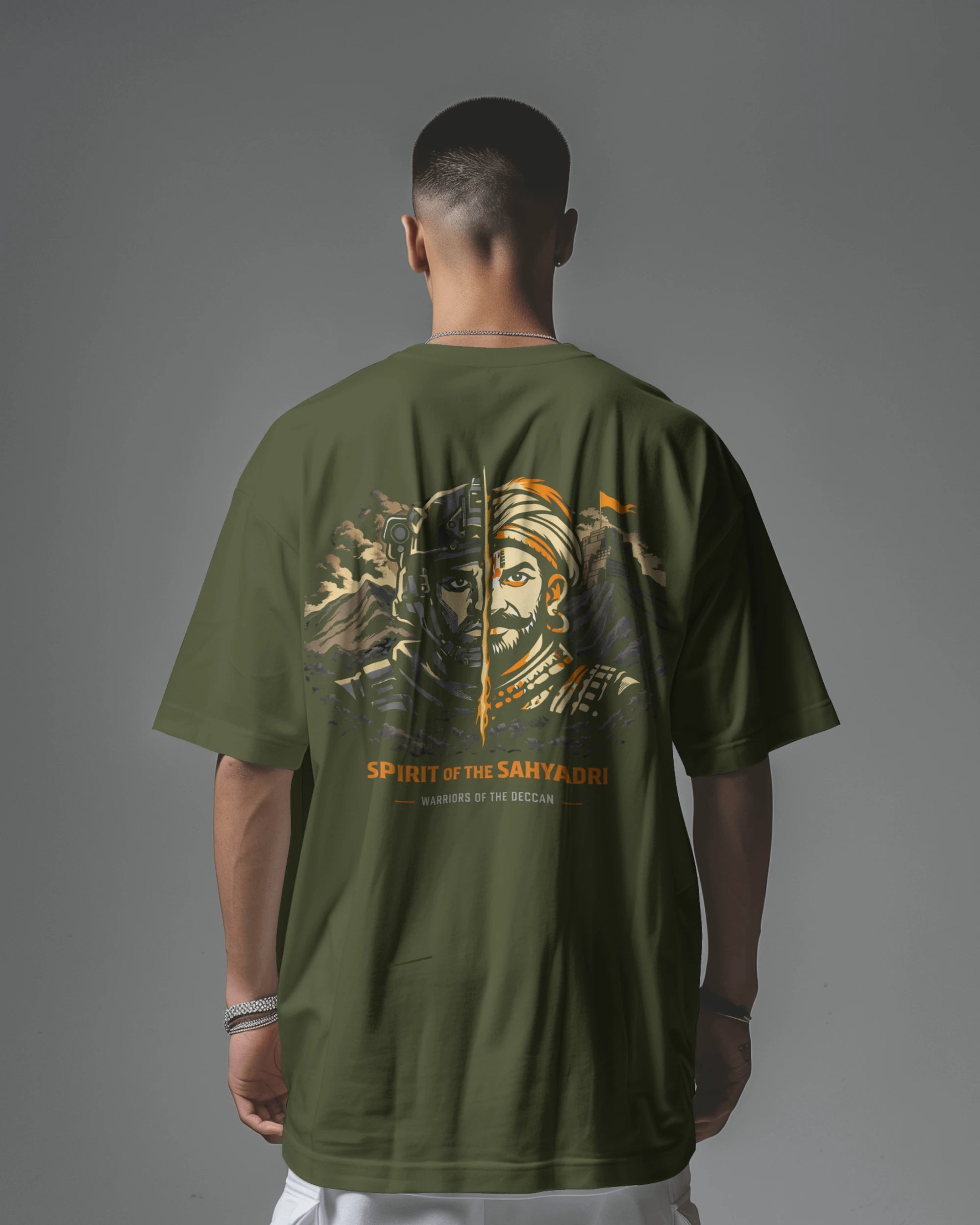 Asian male model wearing a black Sahyadri Spirit Warrior oversized T-shirt by BhaariGear, casual scene with urban background.