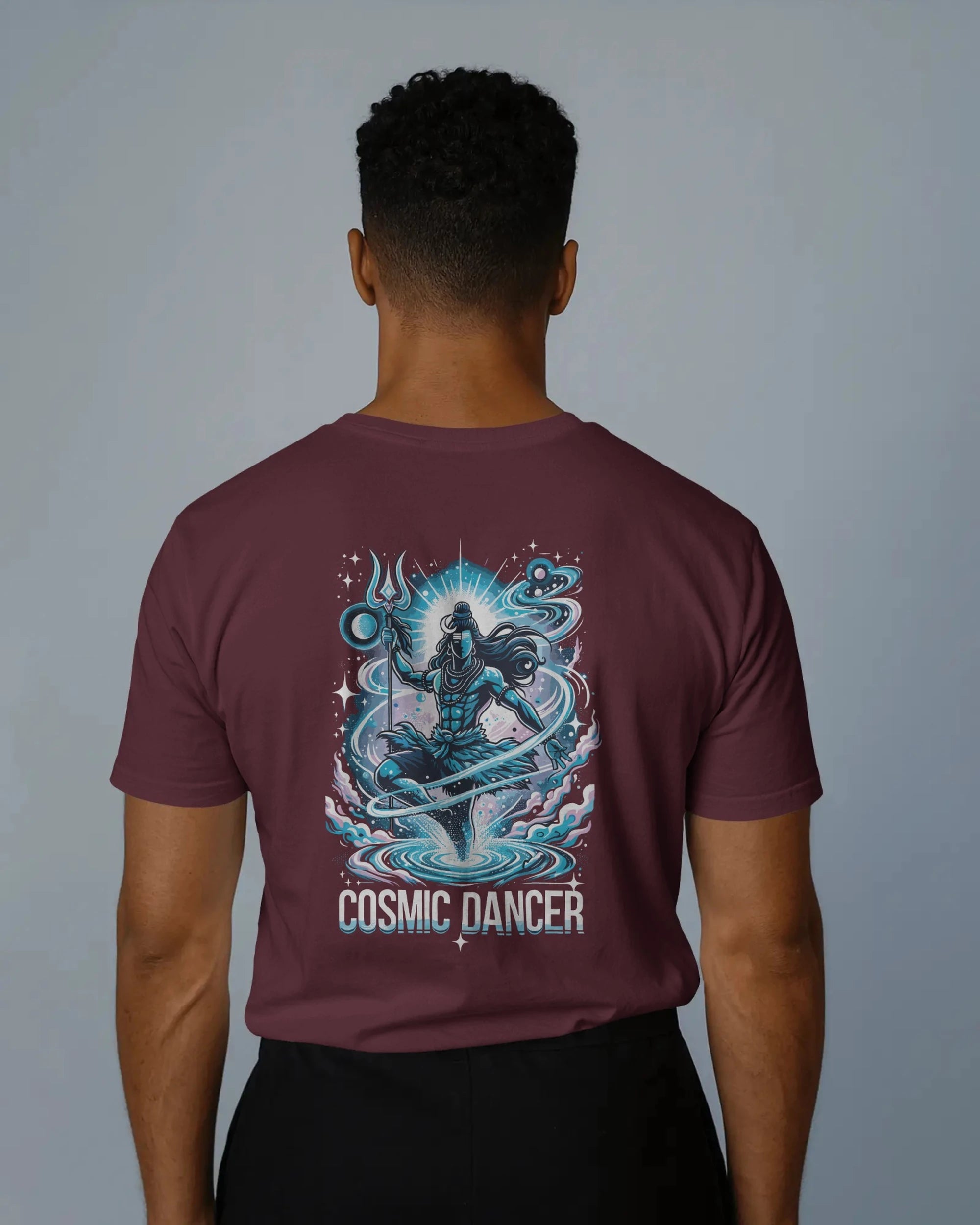 Person wearing a maroon t-shirt with 'Cosmic Dancer' design on the back against a gray background