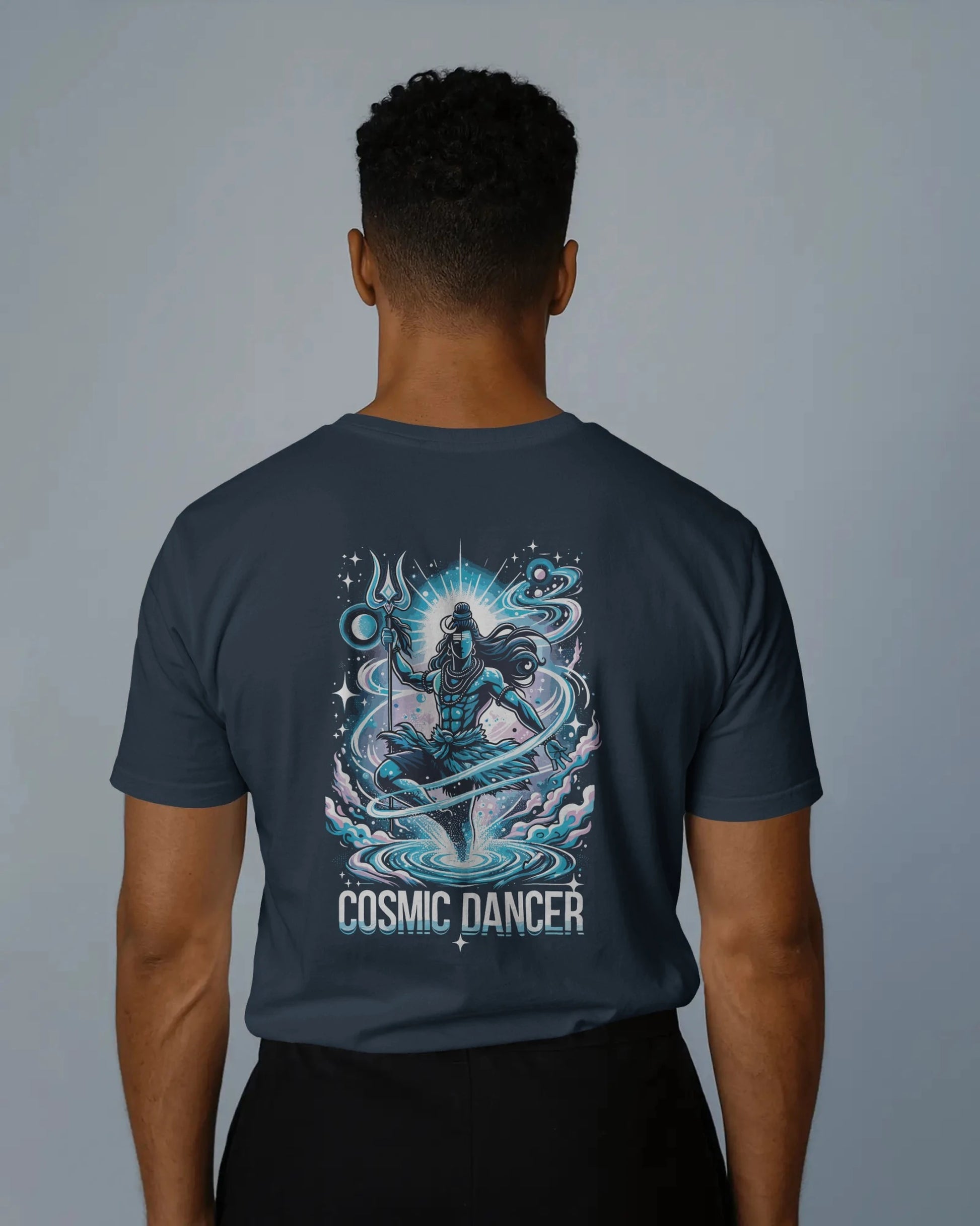Person wearing a t-shirt with 'Cosmic Dancer' design on the back against a gray background
