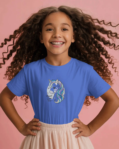 Young girl wearing a blue t-shirt with a unicorn design on a pink background