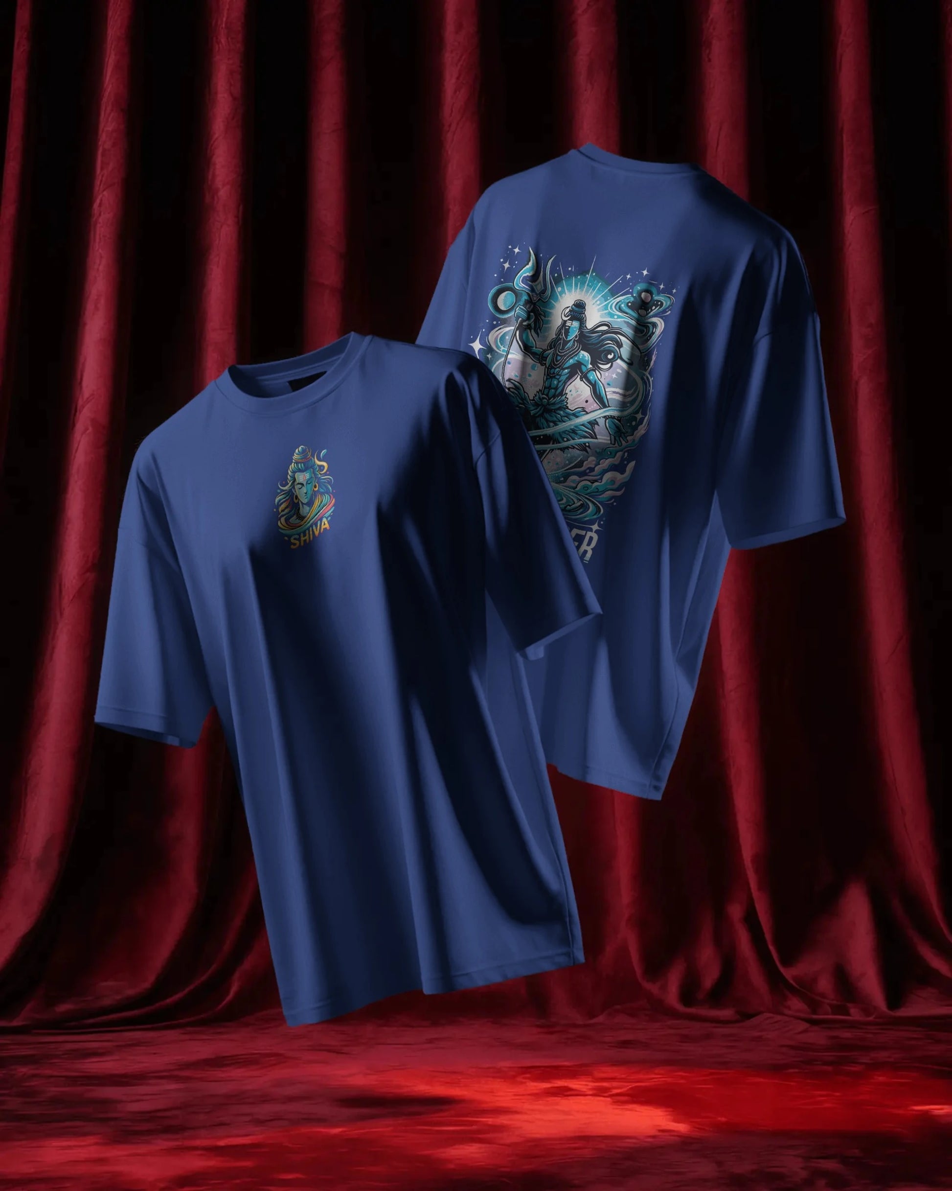 Two Royal blue t-shirts with graphic designs on a red curtain background