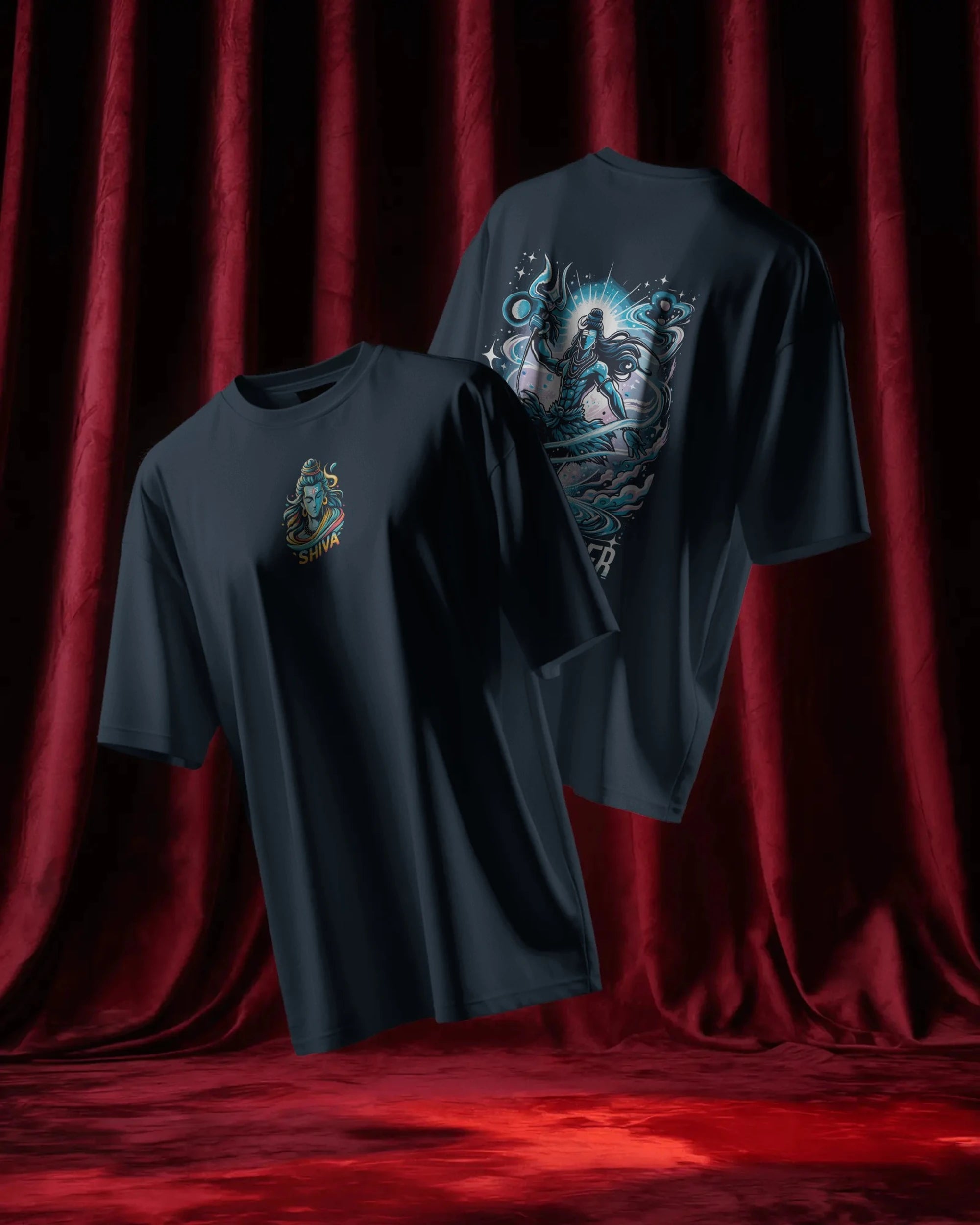 Two dark blue t-shirts with graphic designs on a red curtain background