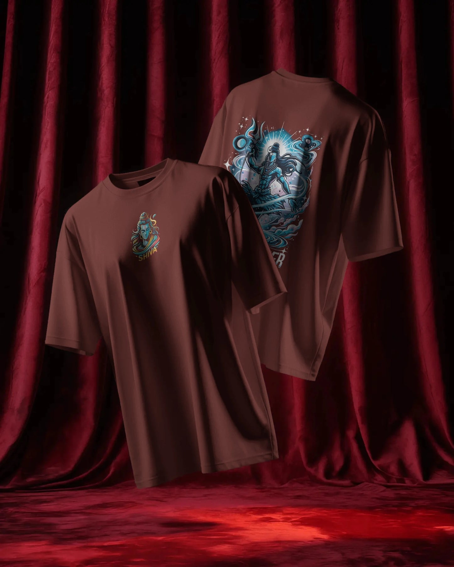 Two brick red t-shirts with graphic designs on a red curtain background