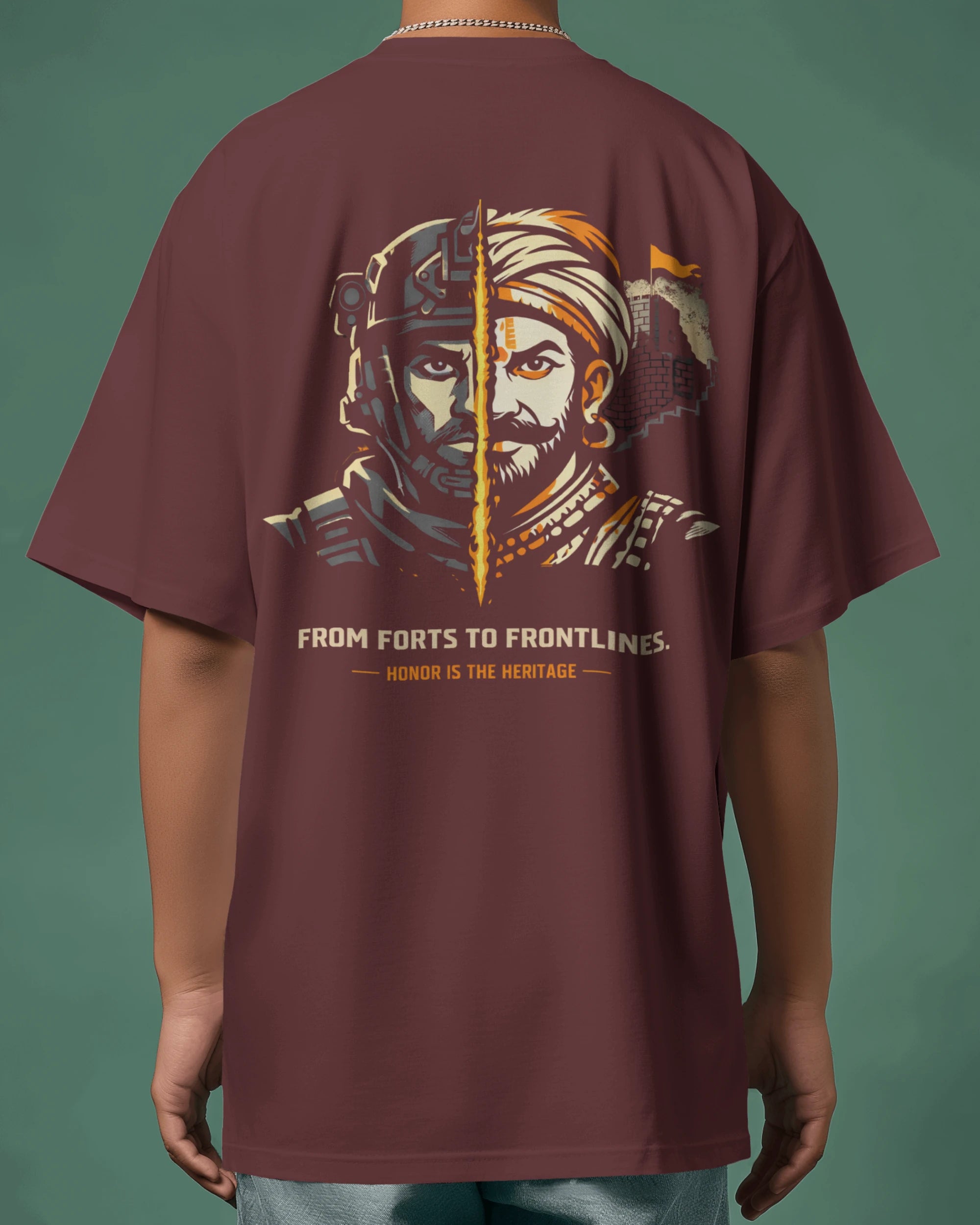 Maroon t-shirt with warrior graphic and text on the back, on a person against a green background