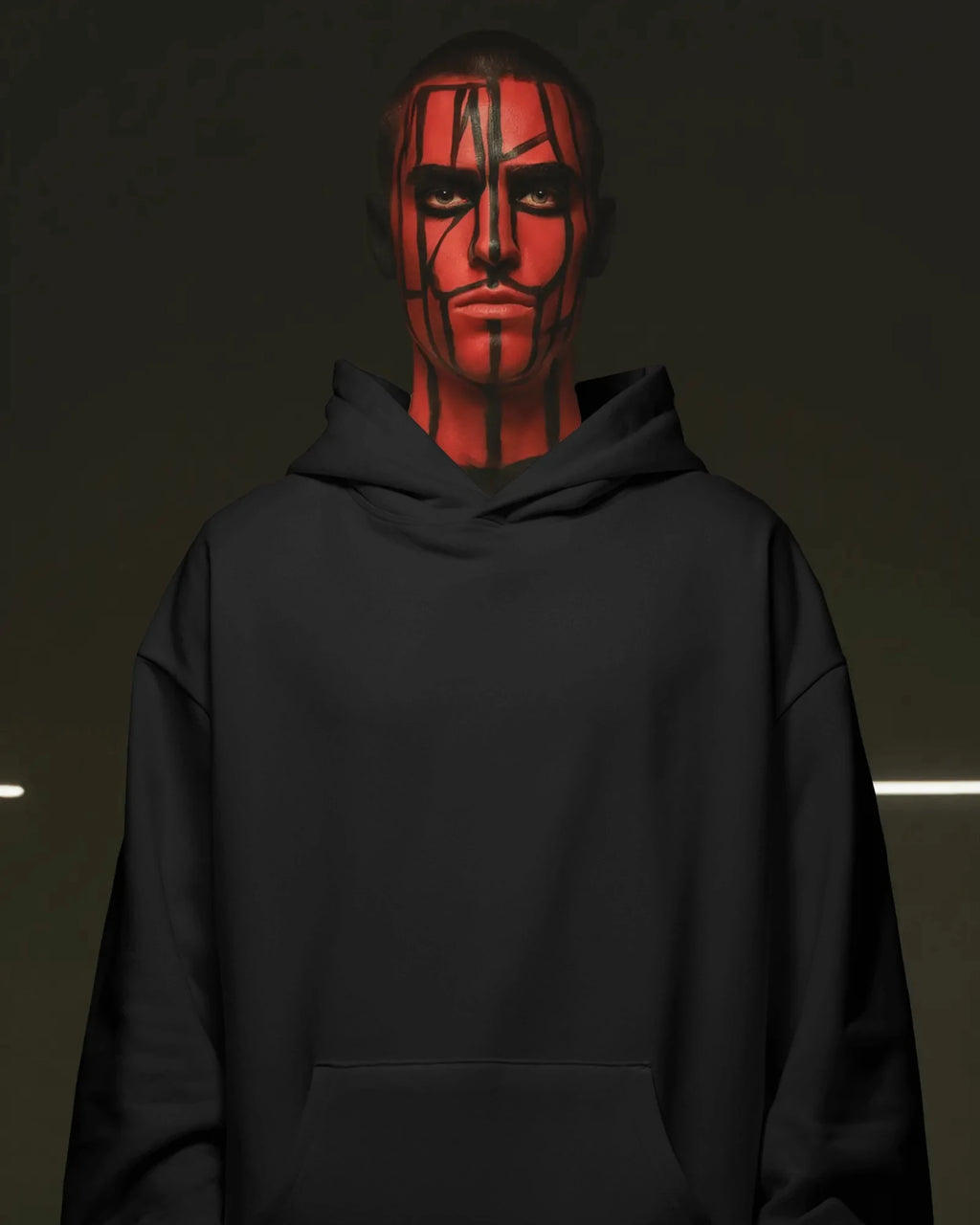 Person wearing a black pull over hoodie with red face paint against a dark background