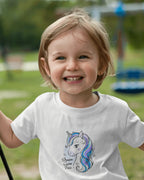 Child wearing a white t-shirt with a unicorn design outdoors