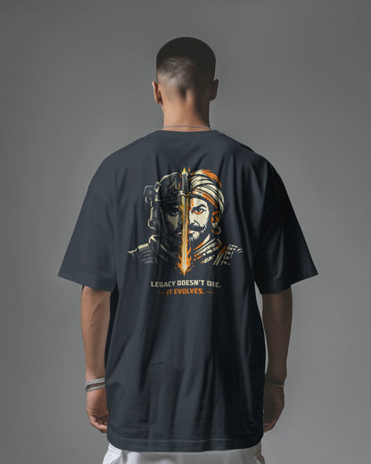 Person wearing a dark navy blue t-shirt with a graphic design on the back against a gray background