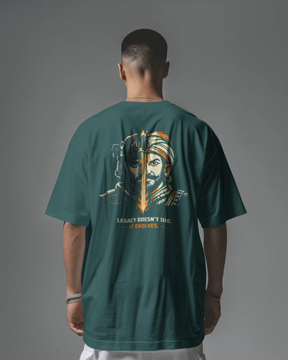 Person wearing a petrol blue  t-shirt with a graphic design on the back against a gray background