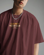 Person wearing a maroon t-shirt with 'Legacy Never Dies' text on a gray background