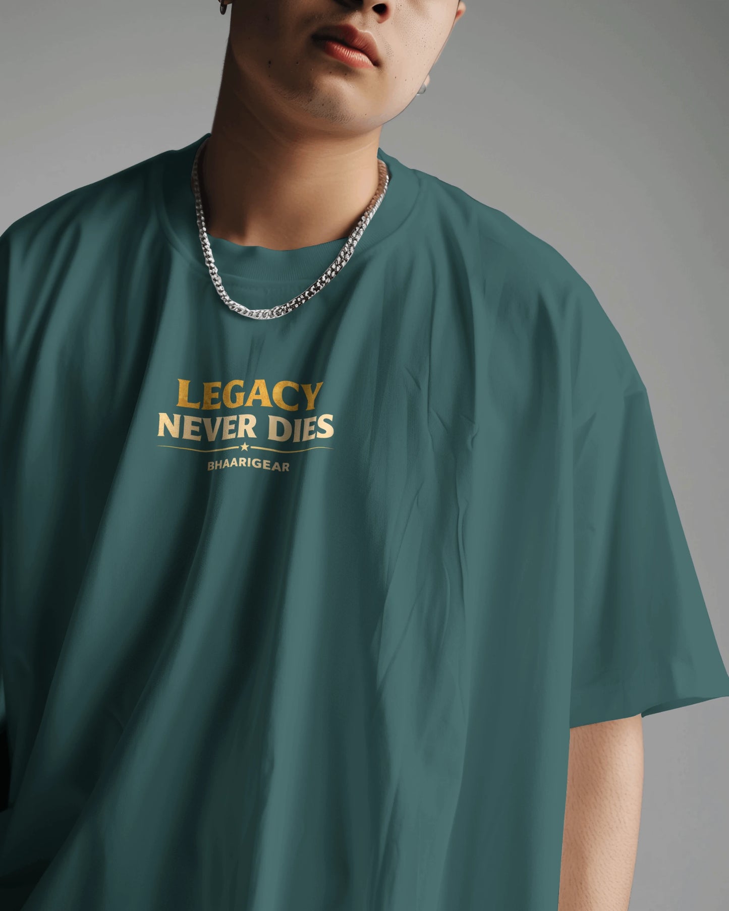 Person wearing a petrol blue t-shirt with 'Legacy Never Dies' text on a gray backgroun