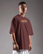 Man wearing a maroon t-shirt with 'Legacy Never Dies' text on a gray background