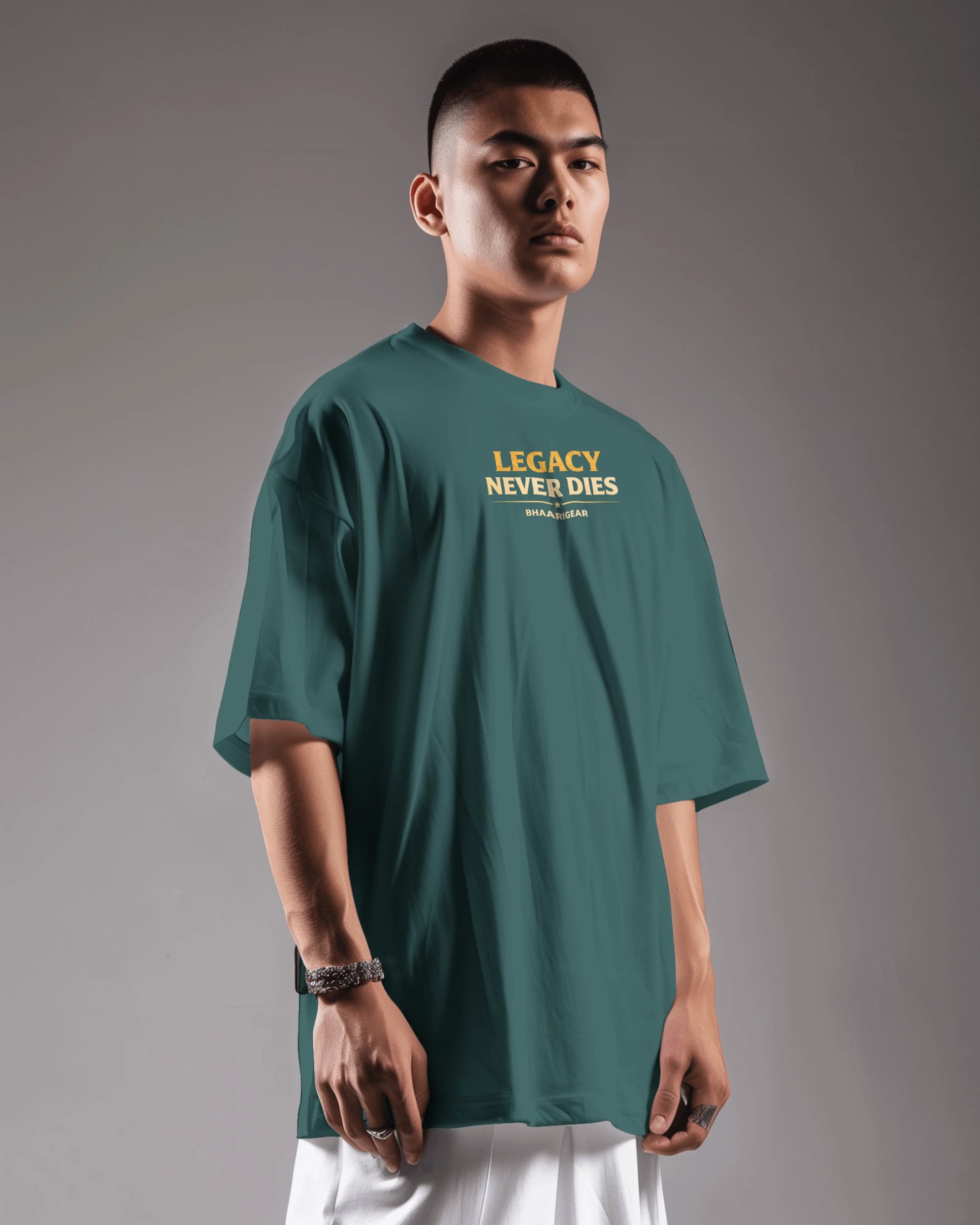 Person wearing a petrol blue t-shirt with 'Legacy Never Dies' text on a gray background