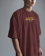 Person wearing a maroon t-shirt with 'Legacy Never Dies' text on a gray background