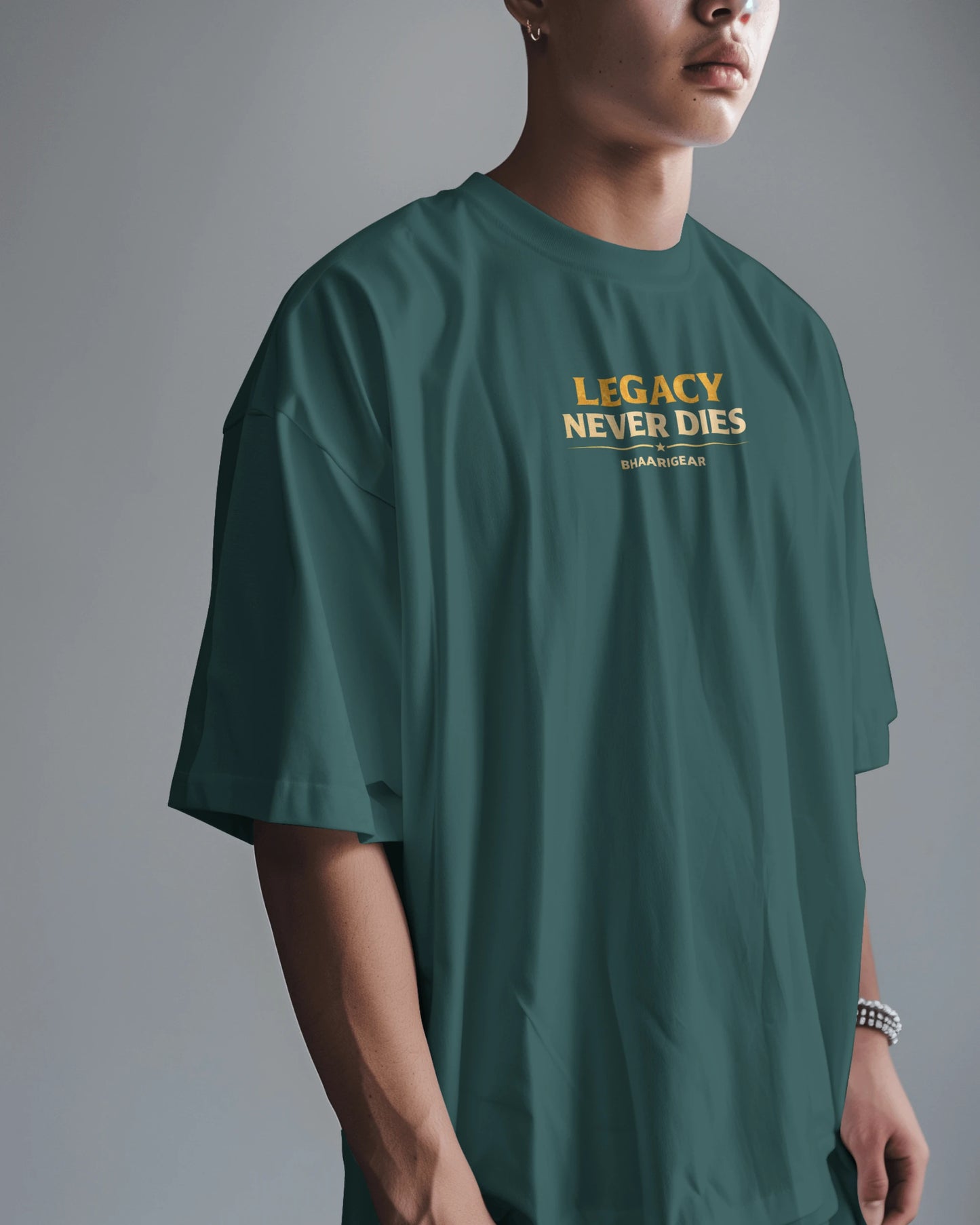 Person wearing a petrol blue t-shirt with 'Legacy Never Dies' text on a gray background