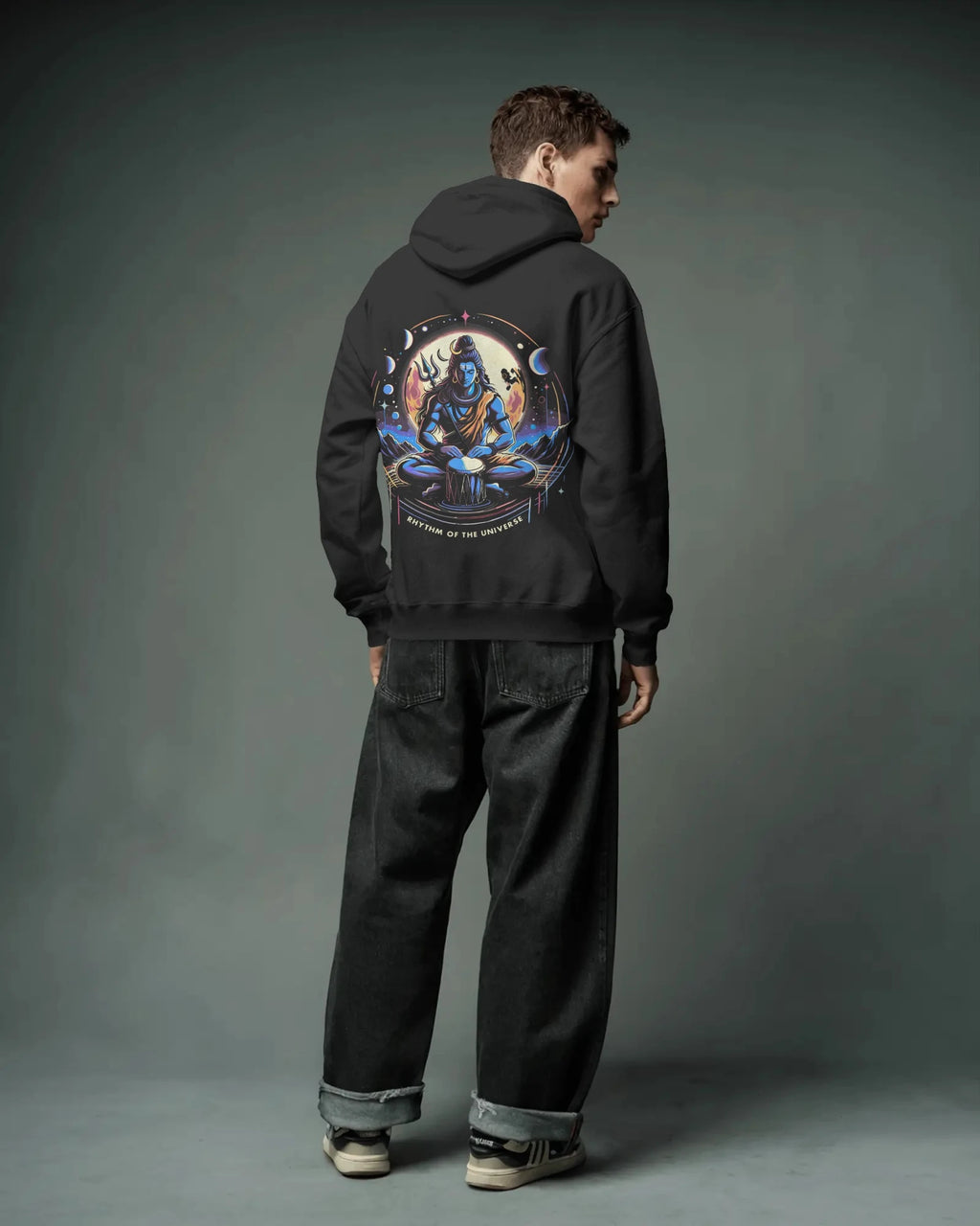 Person wearing a black hoodie with a colorful graphic on the back against a gray background