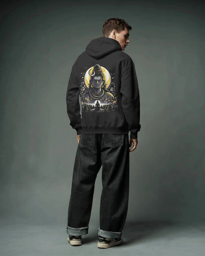 Person wearing a black pull over hoodie with a graphic design on the back against a gray background