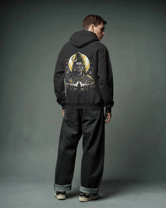 Person wearing a black pull over hoodie with a graphic design on the back against a gray background