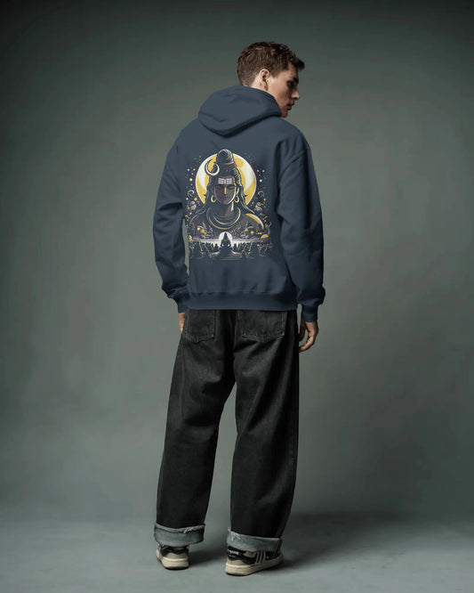 Person wearing a navy blue pull over hoodie with a graphic design on the back against a gray background