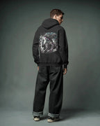 Person wearing a black Pullover hoodie with a graphic design on the back against a gray background